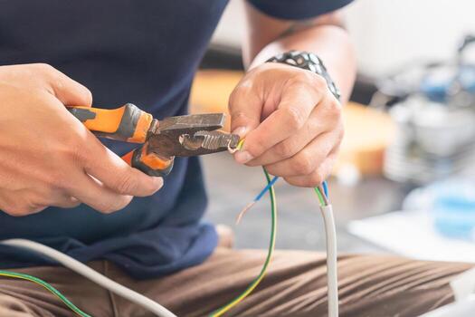 technician man connecting electric wires with pliers to install new air conditioning repair service and install new air conditioner concepts photo
