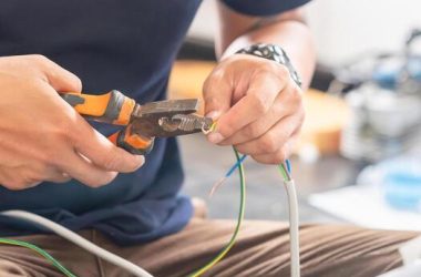 technician man connecting electric wires with pliers to install new air conditioning repair service and install new air conditioner concepts photo